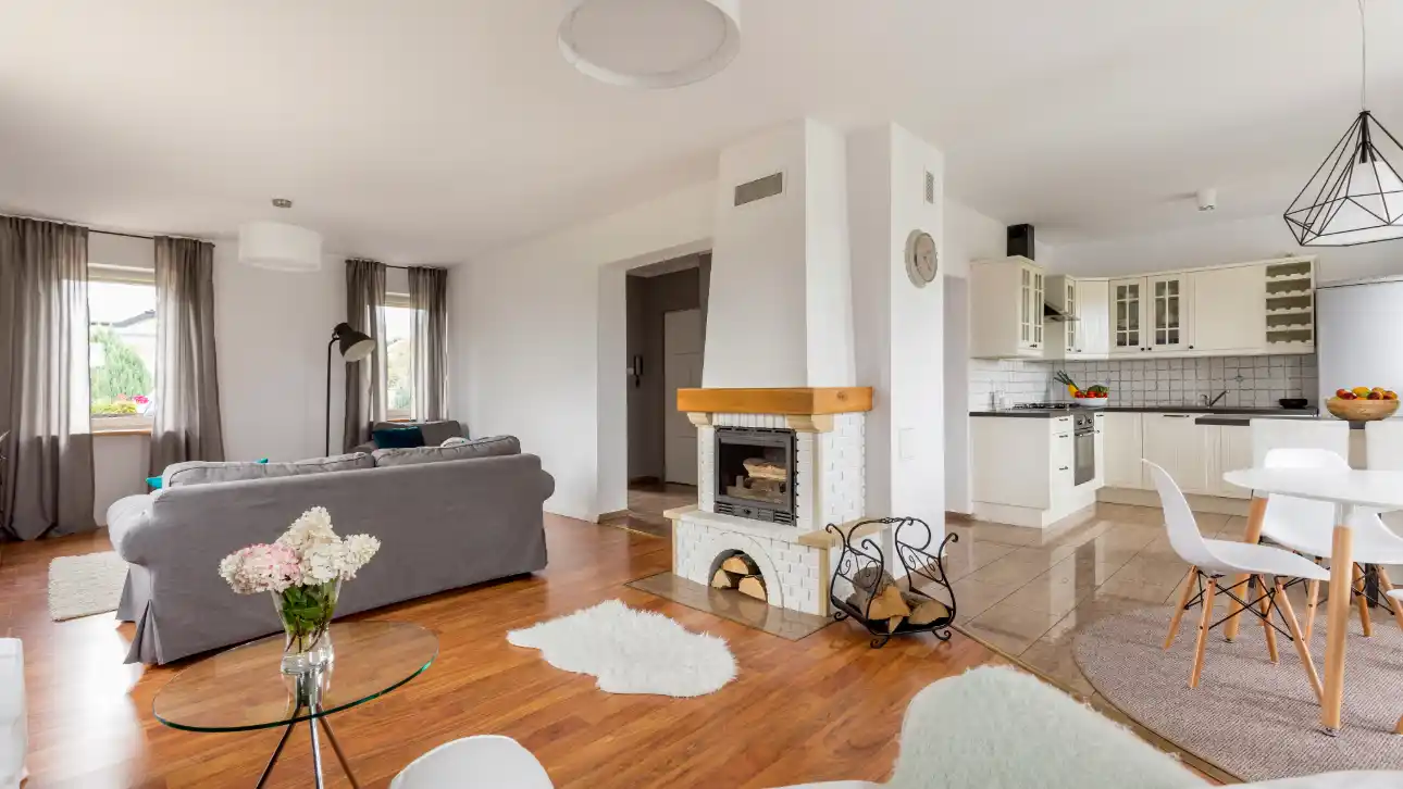 Casa reformada con paredes blancas y suelo de tarima flotante